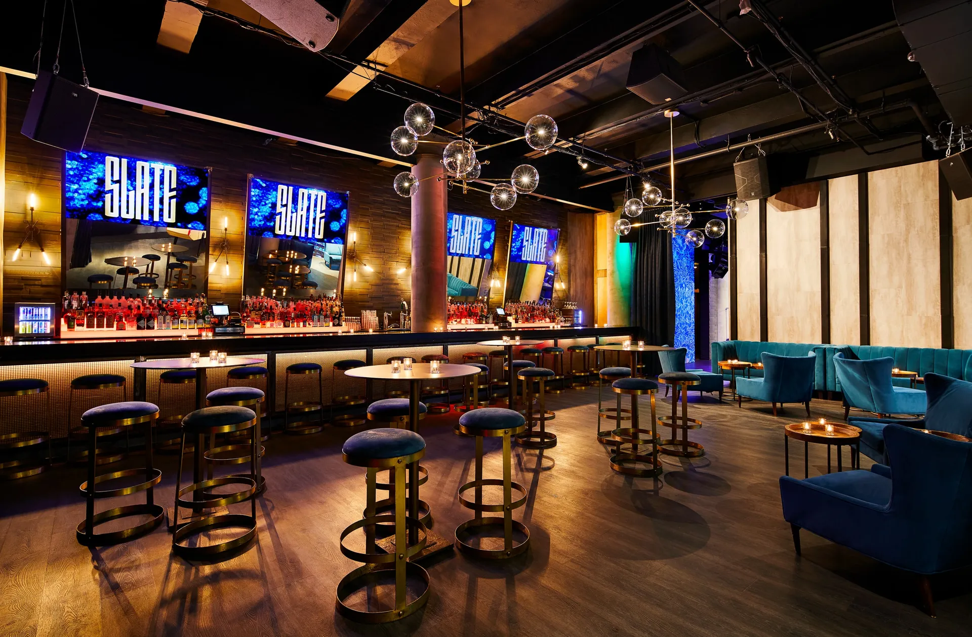 Slate NYC bar and lounge with blue screens and candlelit tables
